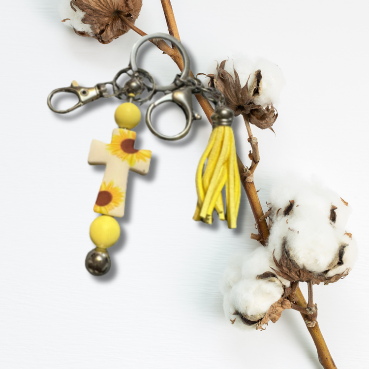 A charming and meaningful accessory that combines the beauty of sunflowers with the symbolism of a cross. Elevate your daily essentials with this delightful keychain.