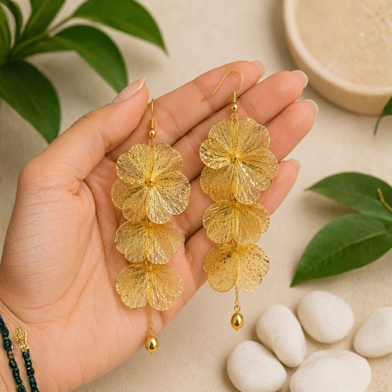 Artful Filigree Flower Drop Earrings held in a hand with a natural background