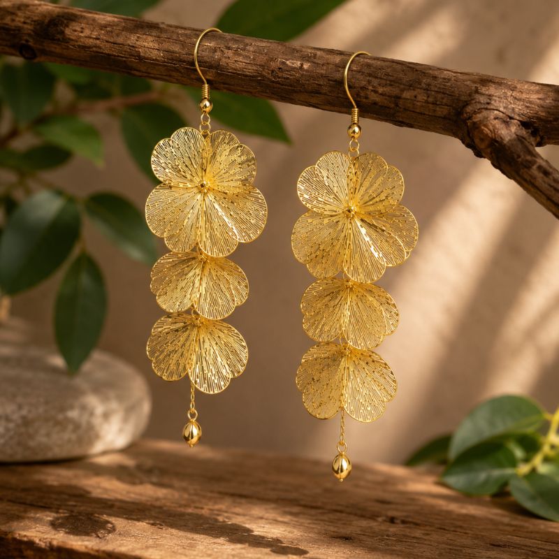 Artful Filigree Flower Drop Earrings hanging on a branch with a natural background