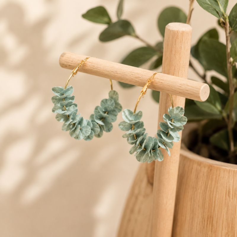 Light blue hoop earrings on a wooden stand with a natural background