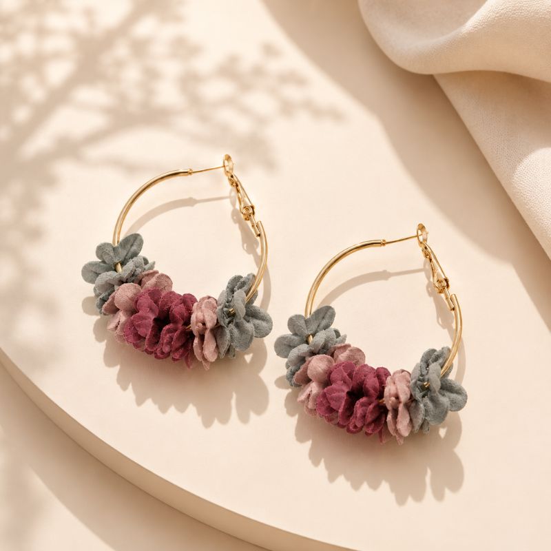 Pair of floral hoop earrings on a beige surface