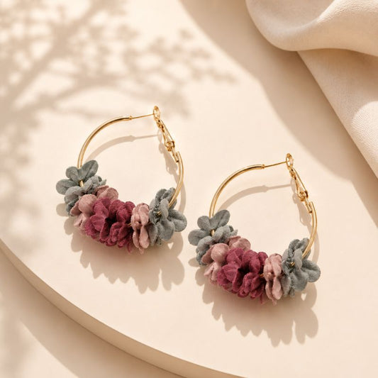 Pair of floral hoop earrings on a beige surface