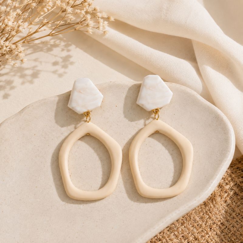 Beige earrings with marble-like tops on a beige fabric background-Designs by Berniemae
