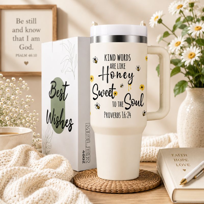 White mug with motivational quote, gift box, and decorative items on a table.