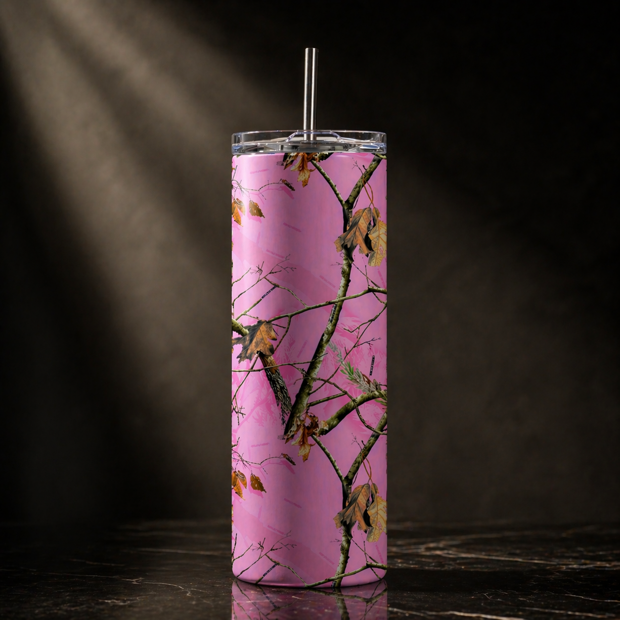 Tumbler with pink camouflage design on a dark background