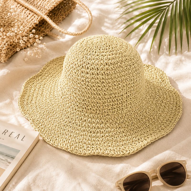 Beige straw hat on a sandy surface with a book and sunglasses nearby-Designs by Berniemae