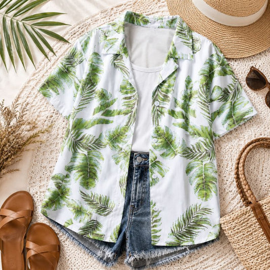 Green leaf-patterned shirt with rolled-up sleeves, sunglasses, sandals, and a hat on a textured surface.- Designs by Berniemae